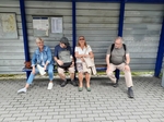 Dvě členky a dva členové SONS sedí na lavičce na vlakovém nádraží