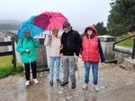 3 Tři členky a jeden člen SONS s deštníky na přehradě Černá Nisa (v pozadí)